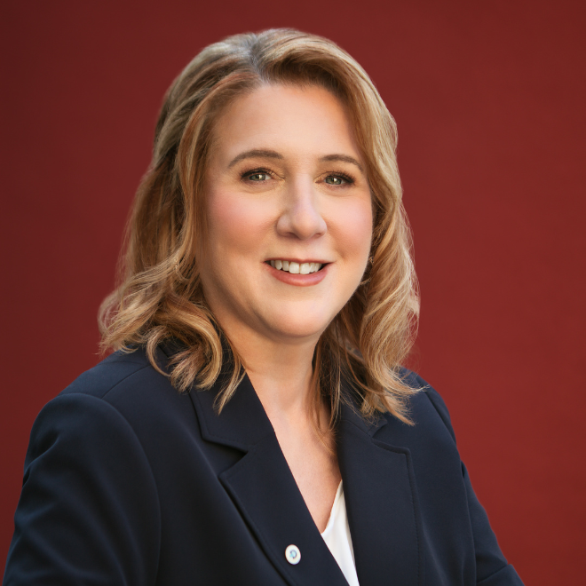 a person smiling in front of a red background