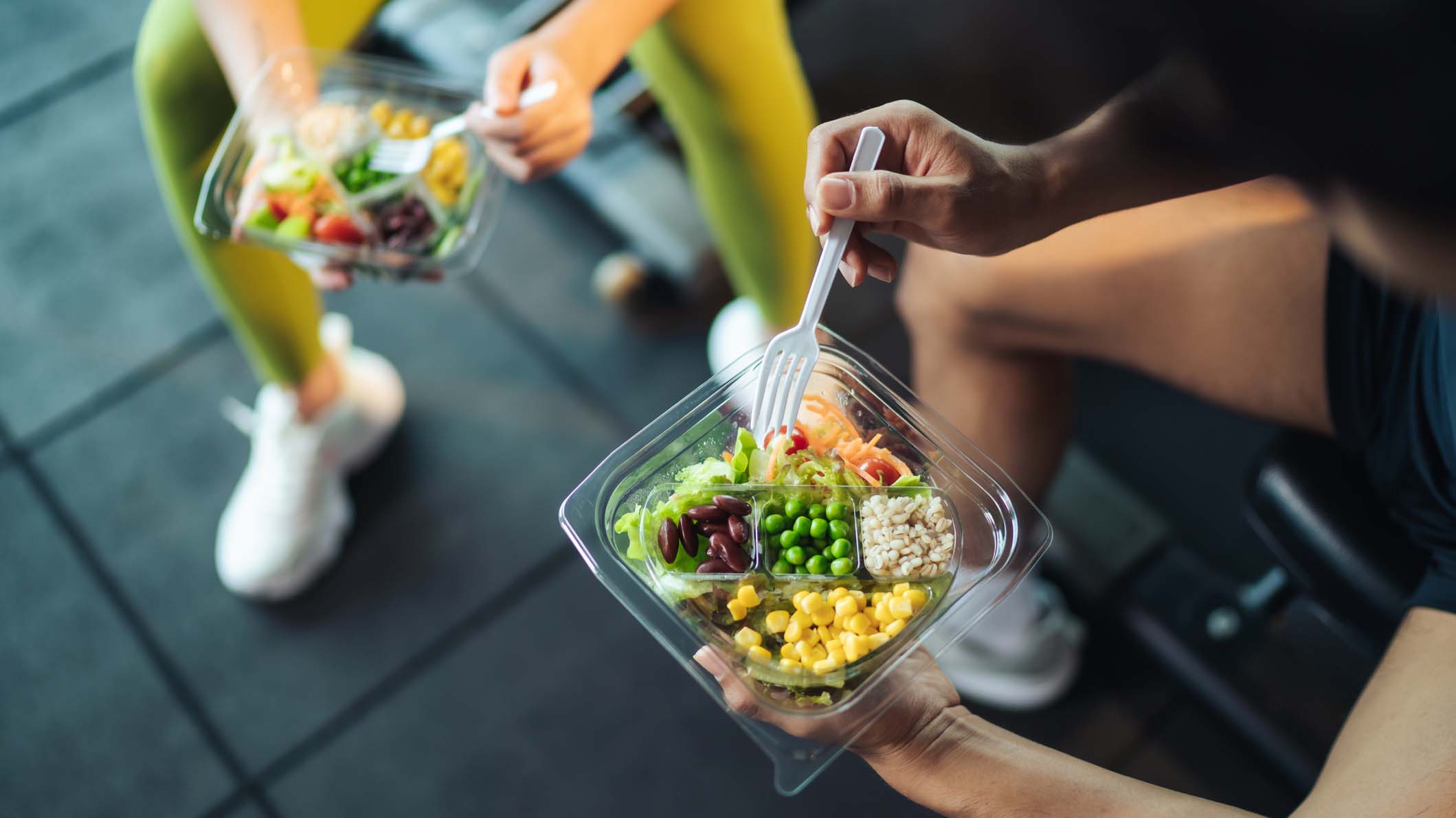 A person holding a fork and a bowl of food